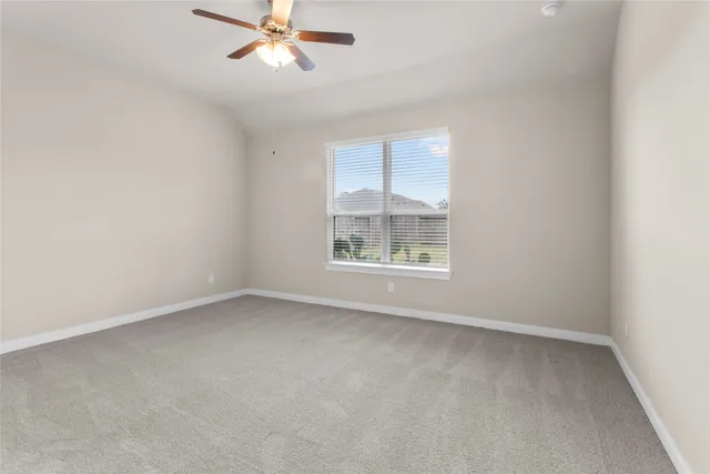an empty room with a window and a fan