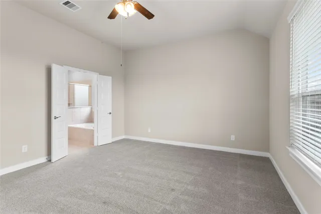 an empty room with fan and windows