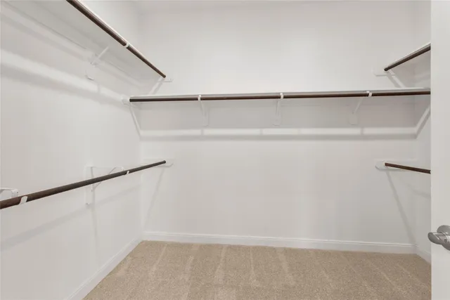a view of walk in closet with empty racks