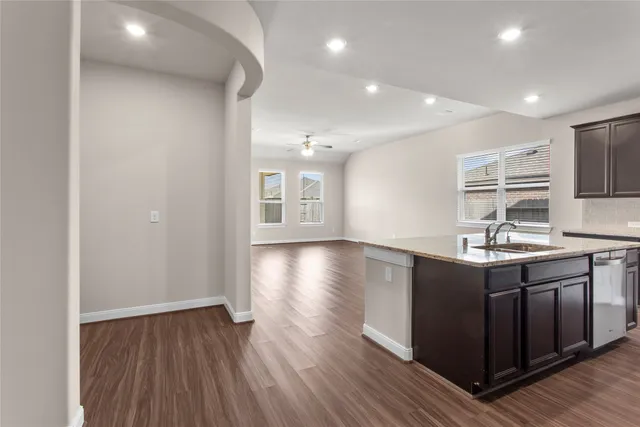 a kitchen with stainless steel appliances granite countertop a sink stove and wooden floor