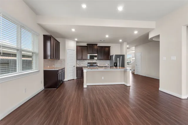 a view of kitchen with cabinets stainless steel appliances a sink and a window