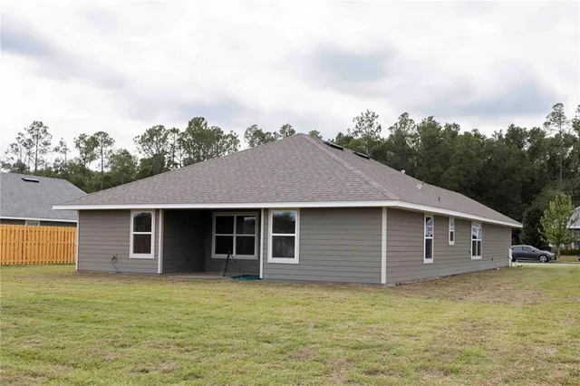 a big house with a big yard plants and large trees