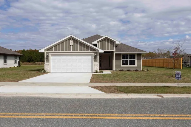 a front view of a house with a garden and garage