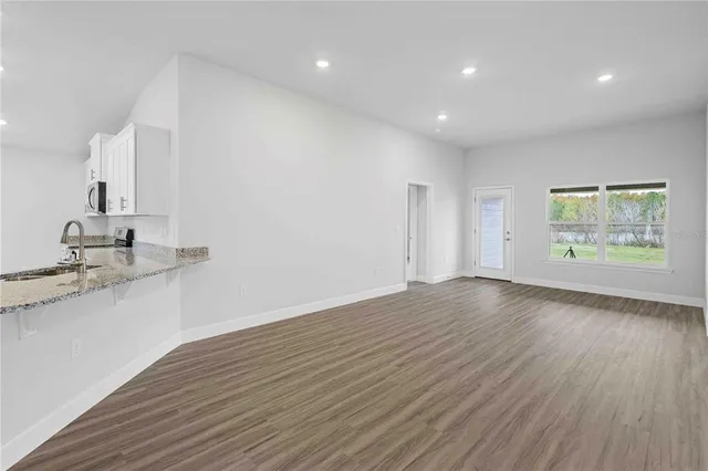 a view of kitchen with wooden floor and electronic appliances