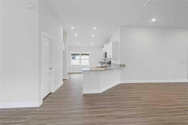 a kitchen with stainless steel appliances granite countertop a sink stove and cabinets