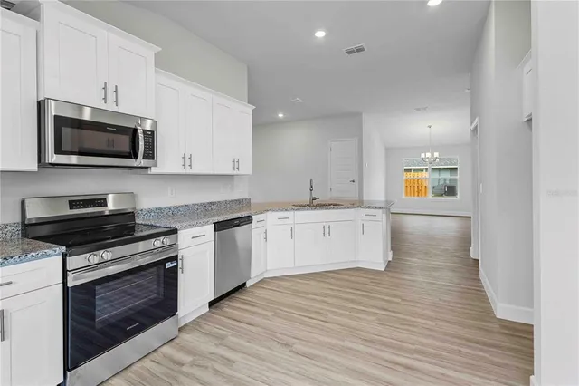 a view of a room with wooden floor fan and window