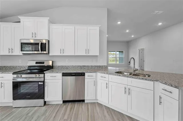 a view of an empty room with wooden floor and closet