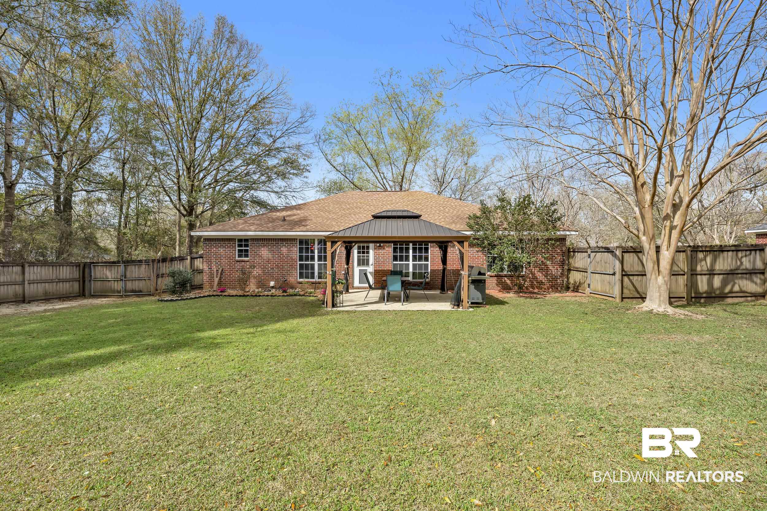 191 Robbins Boulevard Daphne, AL 36526 - Photo 20 of 24 Rear view of property with brick siding, a patio, a fenced backyard, and a shingled roof