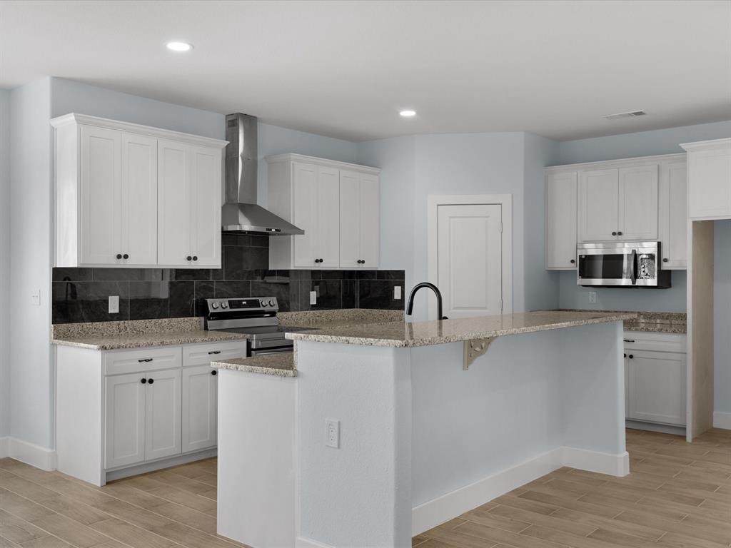 1013 Magnolia Court Springtown, TX 76082 - Photo 11 of 33 a kitchen with stainless steel appliances a sink a stove a microwave a refrigerator a stove and white cabinets