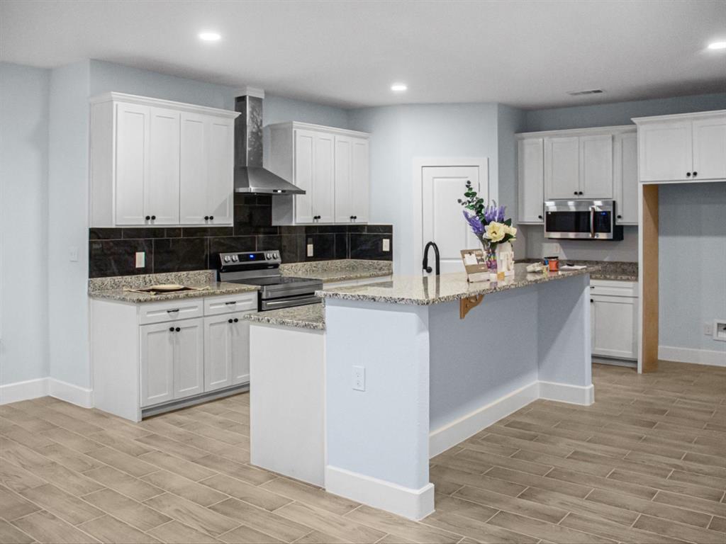 1013 Magnolia Court Springtown, TX 76082 - Photo 12 of 33 a kitchen with kitchen island granite countertop a sink cabinets and stainless steel appliances