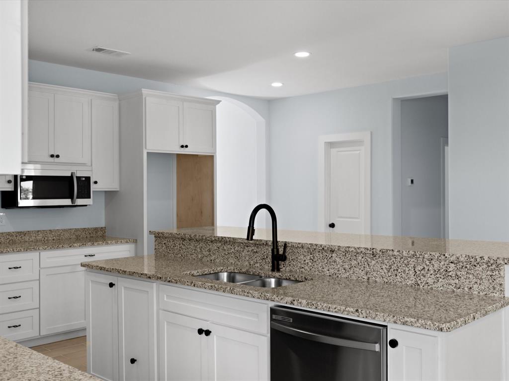 1013 Magnolia Court Springtown, TX 76082 - Photo 13 of 33 a kitchen with granite countertop a sink and cabinets