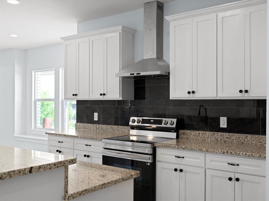 1013 Magnolia Court Springtown, TX 76082 - Photo 14 of 33 a kitchen with granite countertop a stove a sink and dishwasher with white cabinets