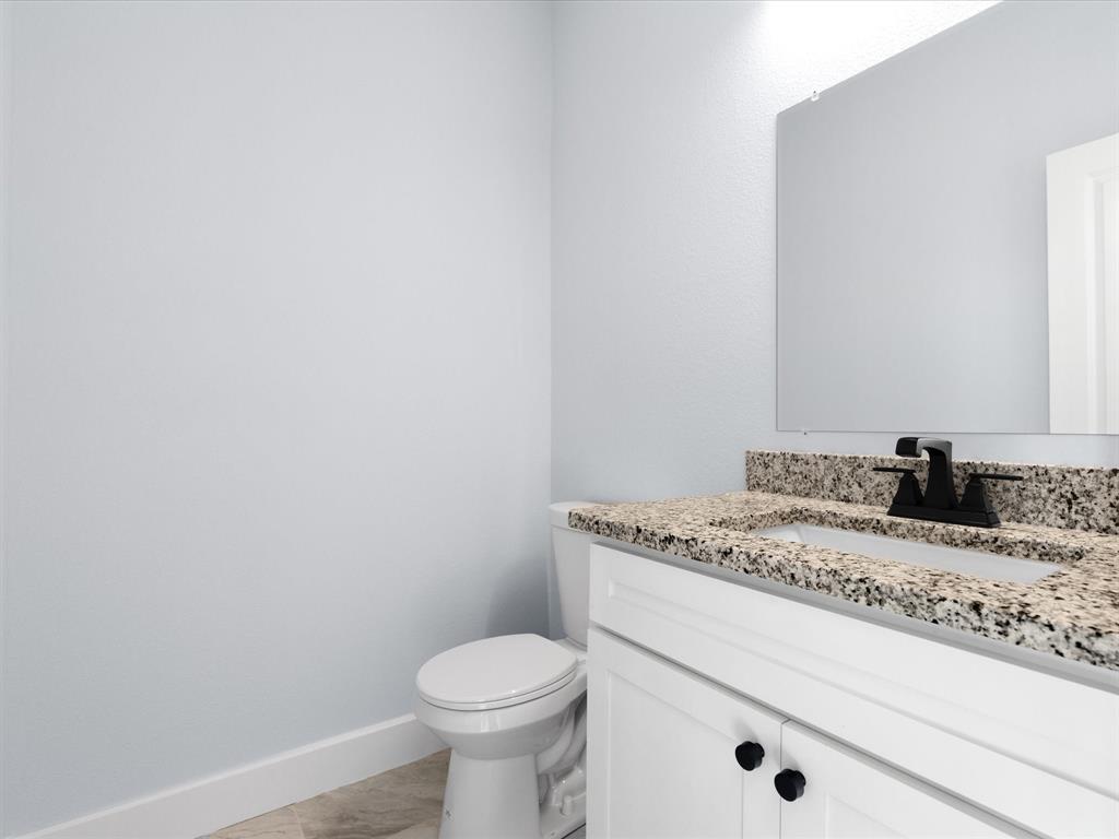 1013 Magnolia Court Springtown, TX 76082 - Photo 19 of 33 a bathroom with a granite countertop toilet and sink