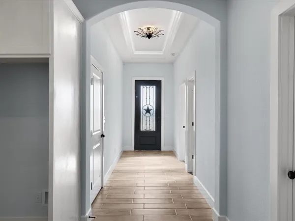 a view of a hallway with wooden floor and a bathroom