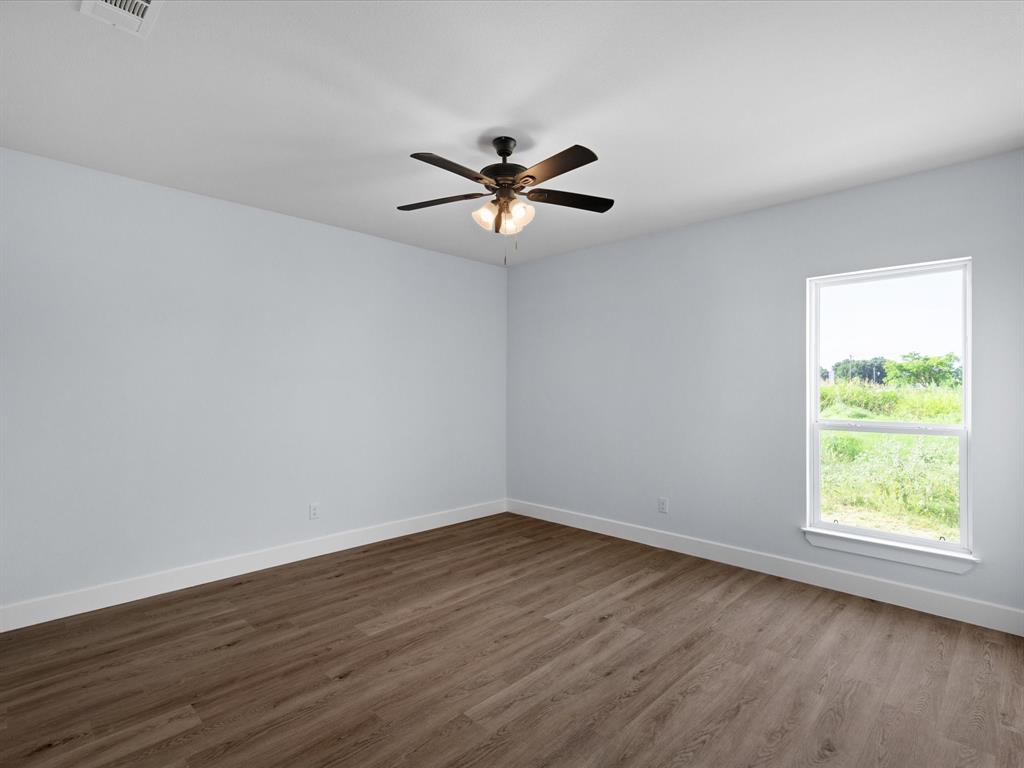 1013 Magnolia Court Springtown, TX 76082 - Photo 26 of 33 a view of a room with wooden floor and a ceiling fan