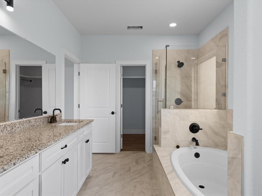 1013 Magnolia Court Springtown, TX 76082 - Photo 27 of 33 a bathroom with a granite countertop tub a sink and a large mirror