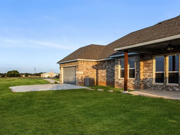 a view of a house with a yard and sitting area