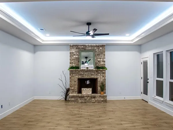 an empty room with fireplace and wooden floor