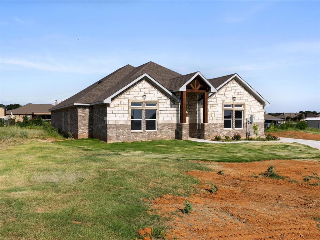 1013 Magnolia Court Springtown, TX 76082 - Photo 31 of 33 a front view of a house with a garden and yard