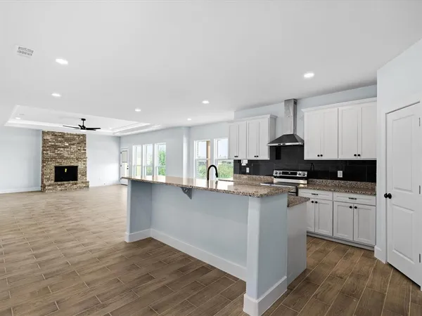 a kitchen with stainless steel appliances granite countertop a stove top oven a sink a counter space and cabinets