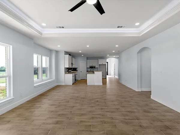 a view of open kitchen with white cabinets and wooden floor