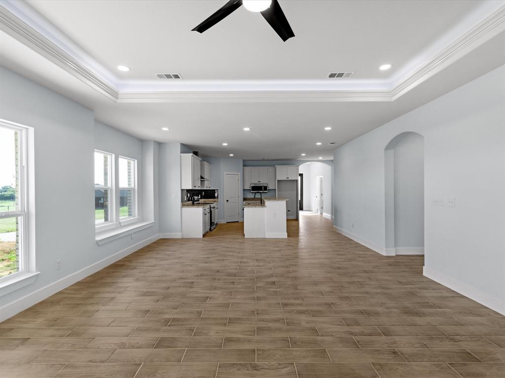 1013 Magnolia Court Springtown, TX 76082 - Photo 8 of 33 a view of open kitchen with white cabinets and wooden floor