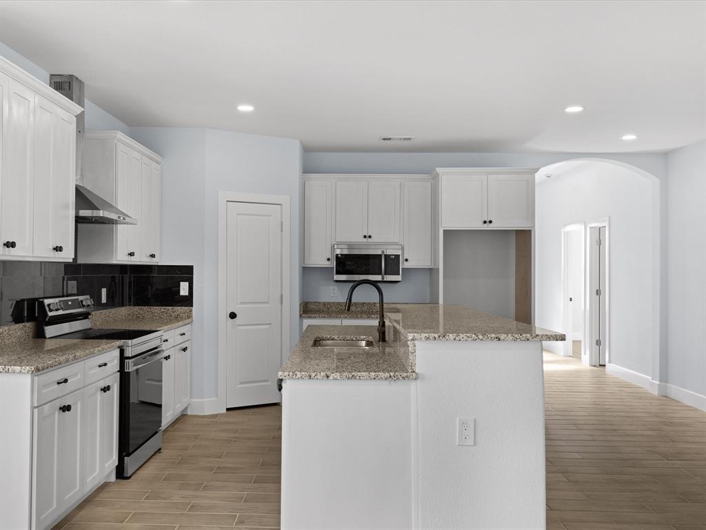 1013 Magnolia Court Springtown, TX 76082 - Photo 9 of 33 a kitchen with granite countertop a sink stove and refrigerator
