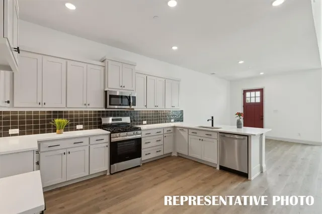 a kitchen with white cabinets stainless steel appliances and sink