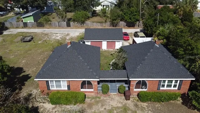 an aerial view of a house with swimming pool and garden