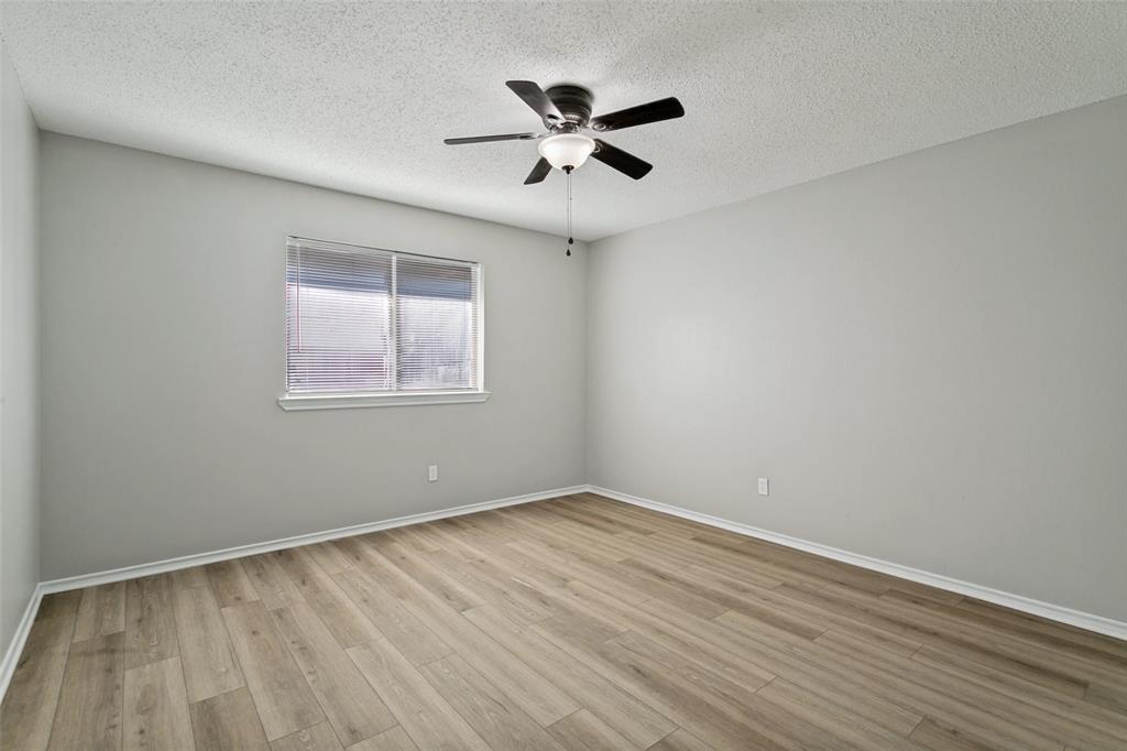 1712 East Peters Colony Road Carrollton, TX 75007 - Photo 15 of 25 Room featuring light-toned wood-finish flooring, neutral gray walls, a window with horizontal blinds, a white ceiling, and a ceiling fan with integrated lighting
