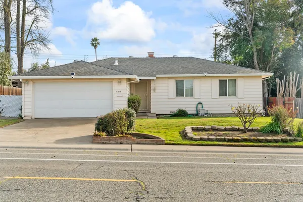 a view of a house with a small yard and potted plants