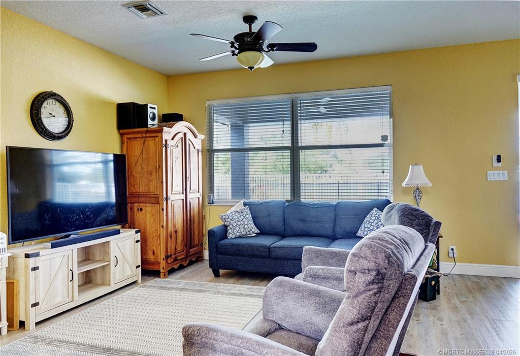 2120 Northwest Marsh Rabbit Lane Jensen Beach, FL 34957 - Photo 27 of 34 a living room with furniture a flat screen tv and a window
