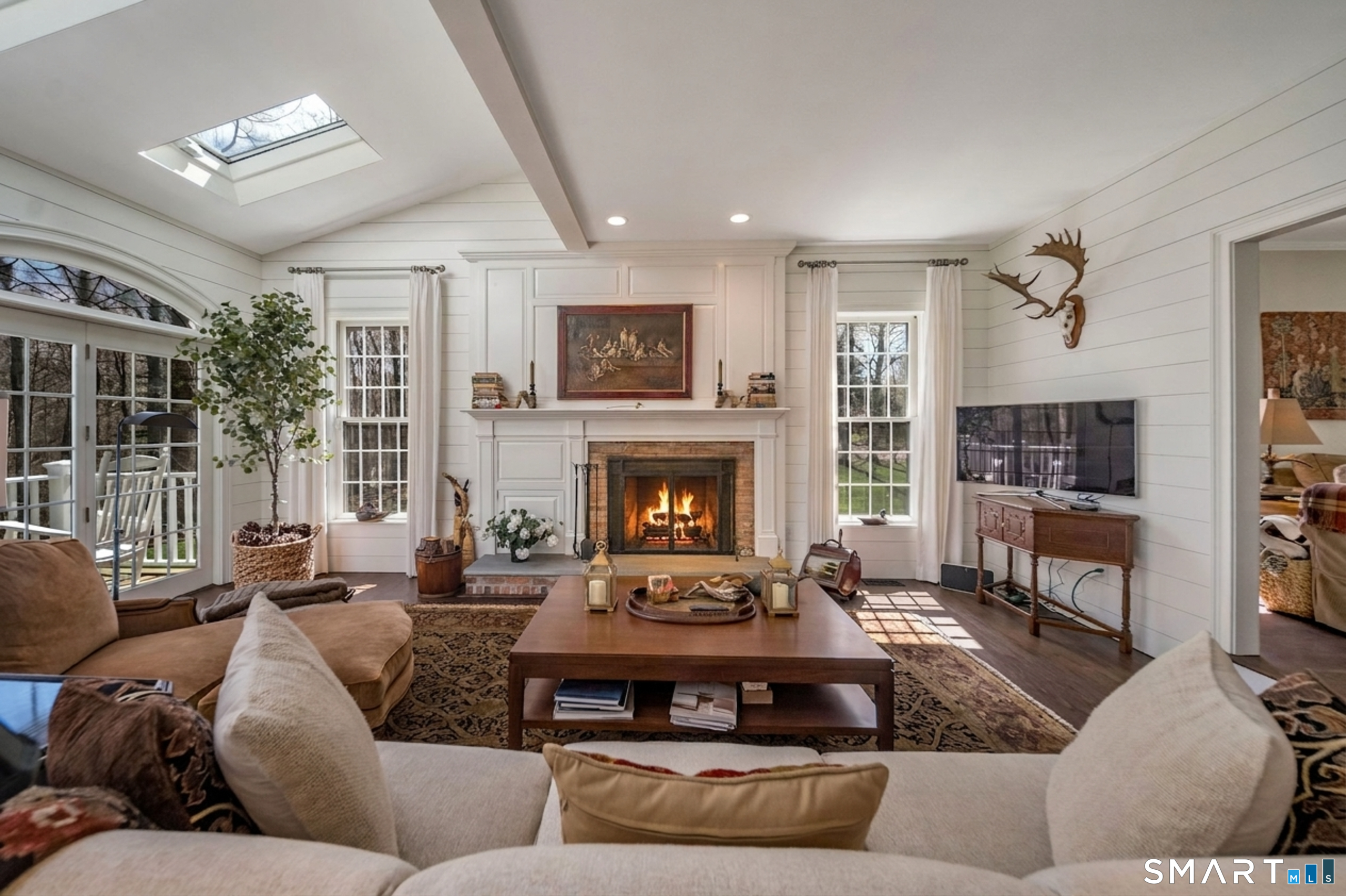 9 Matson Ridge Old Lyme, CT 06371 - Photo 21 of 42 Light filled Great Room with working wood fireplace, 3 skylights, arched lead glass windows and french doors leading out to the mahogany deck