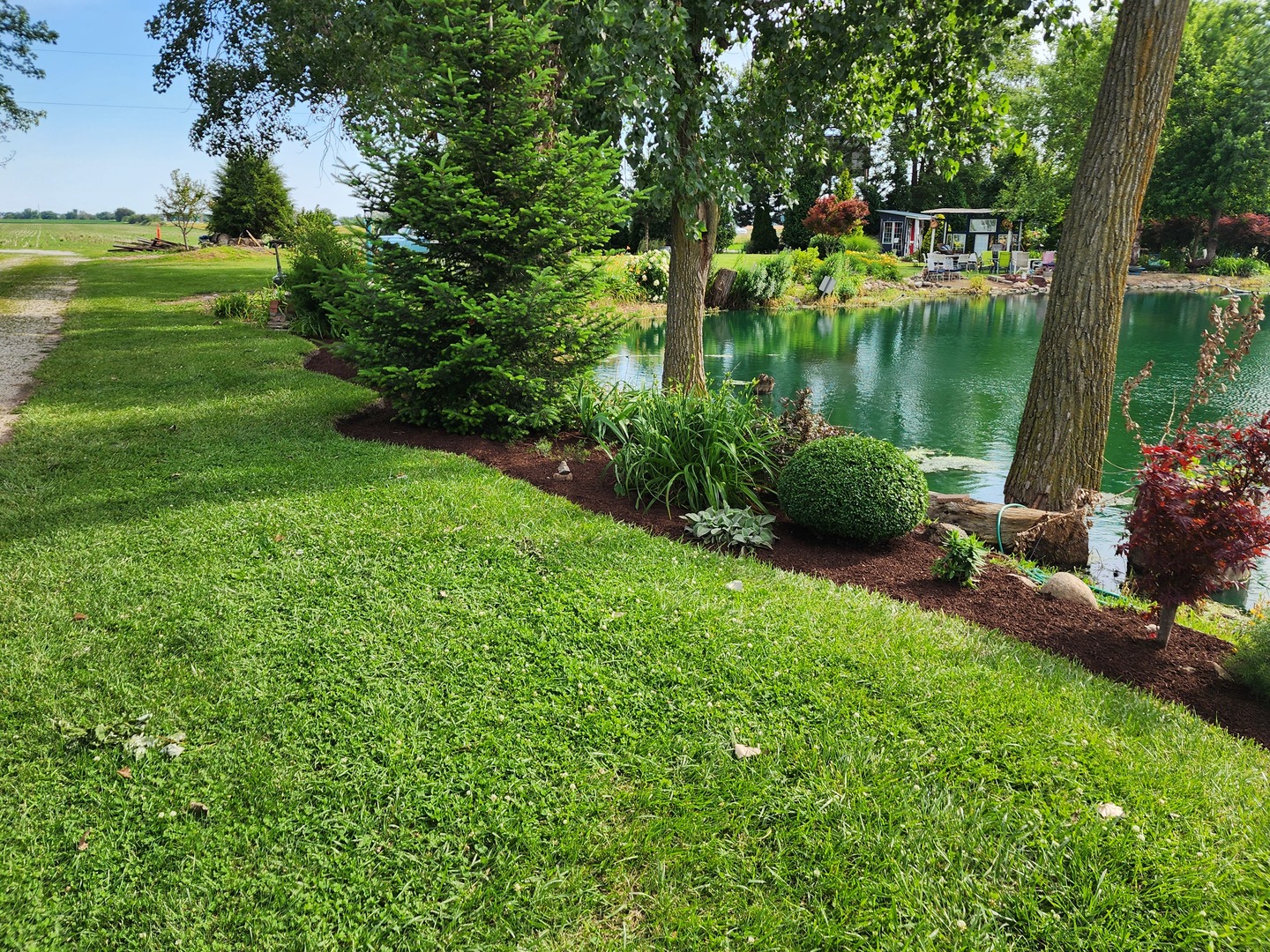 860 East 1100 Road Champaign, IL 61822 - Photo 25 of 60 a view of a lake with a yard and large trees