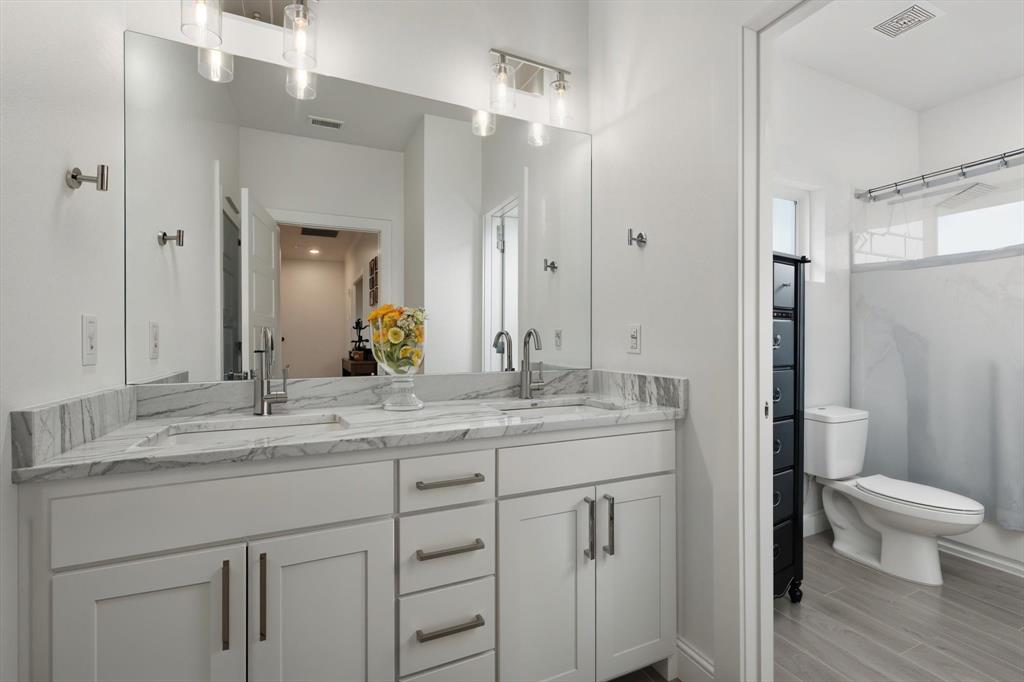121 Bluegrass Trail Springtown, TX 76082 - Photo 25 of 39 a bathroom with a granite countertop sink a toilet and a mirror