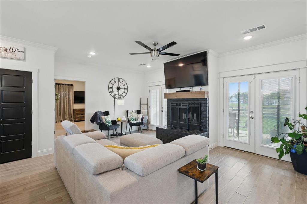 121 Bluegrass Trail Springtown, TX 76082 - Photo 8 of 39 a living room with furniture a fireplace and a flat screen tv
