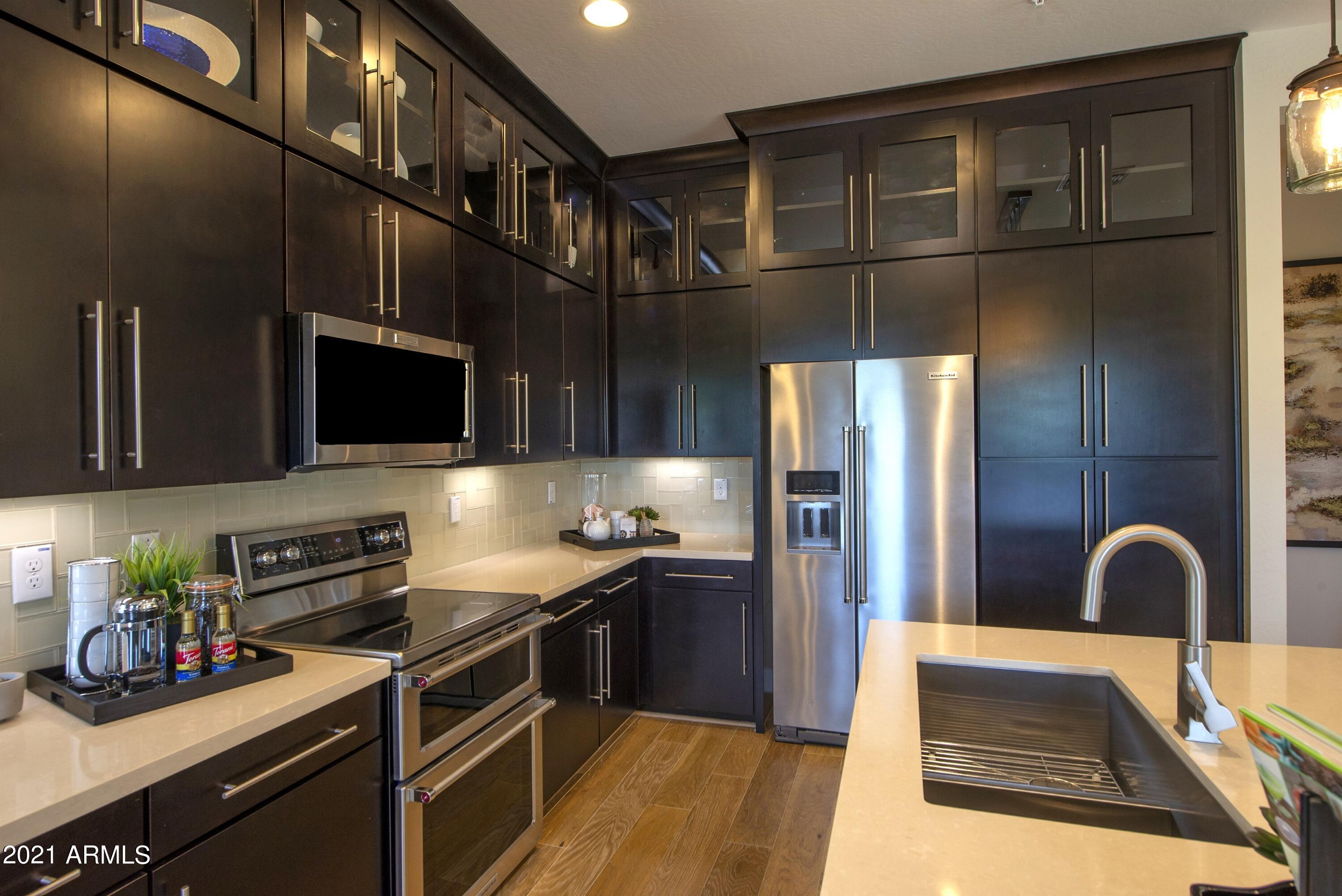 6565 East Thomas Road, Unit 1042 Scottsdale, AZ 85251 - Photo 6 of 22 a kitchen with stainless steel appliances granite countertop a refrigerator and a stove top oven