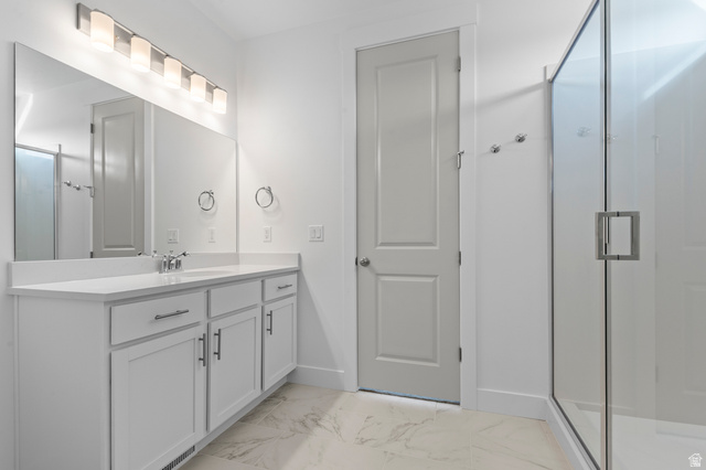 5644 Ibis Road Tooele, UT 84074 - Photo 18 of 19 Spacious bathroom featuring a double vanity with white cabinetry, a large vanity mirror, and a glass-enclosed shower