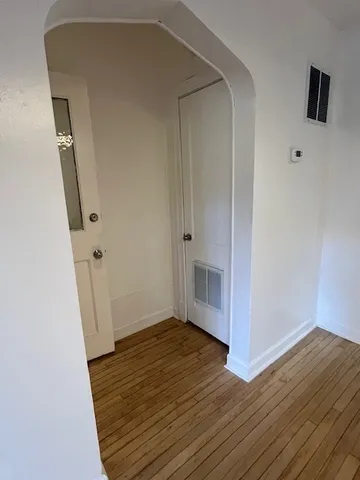 an empty room with wooden floor and white walls