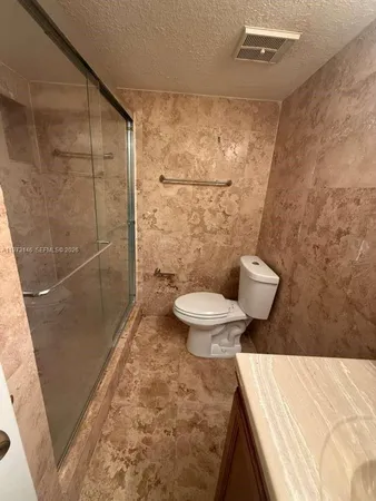 a bathroom with a toilet and a shower
