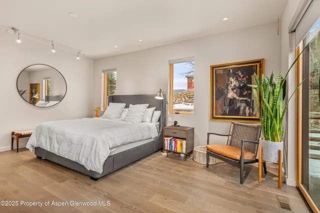 a bedroom with a bed and a large window