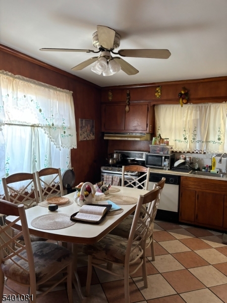 306 East 34th Street Paterson, NJ 07504 - Photo 7 of 12 a kitchen with a stove a sink a dining table and chairs