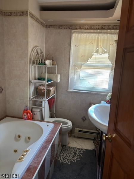 306 East 34th Street Paterson, NJ 07504 - Photo 10 of 12 a bathroom with a bathtub a window and a toilet