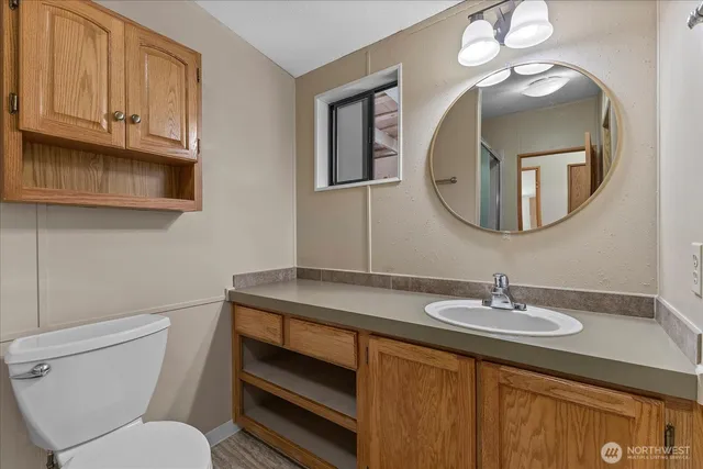 a bathroom with a toilet a sink and a mirror