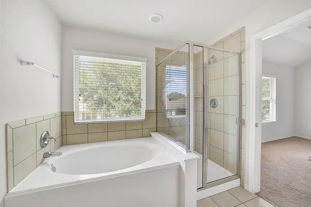a white bath tub sitting next to a shower