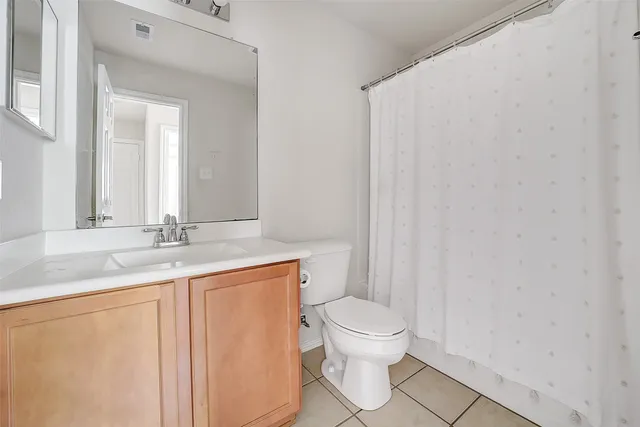 a bathroom with a granite countertop sink a toilet and a mirror