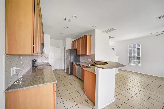 a kitchen with stainless steel appliances granite countertop a stove a sink and a microwave
