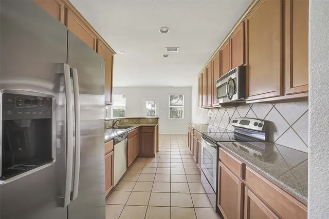 a kitchen with stainless steel appliances granite countertop a sink and a stove