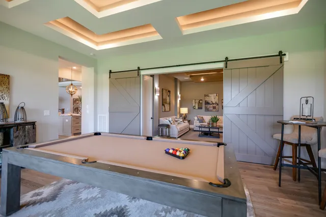 a bedroom with a bed chandelier and a window