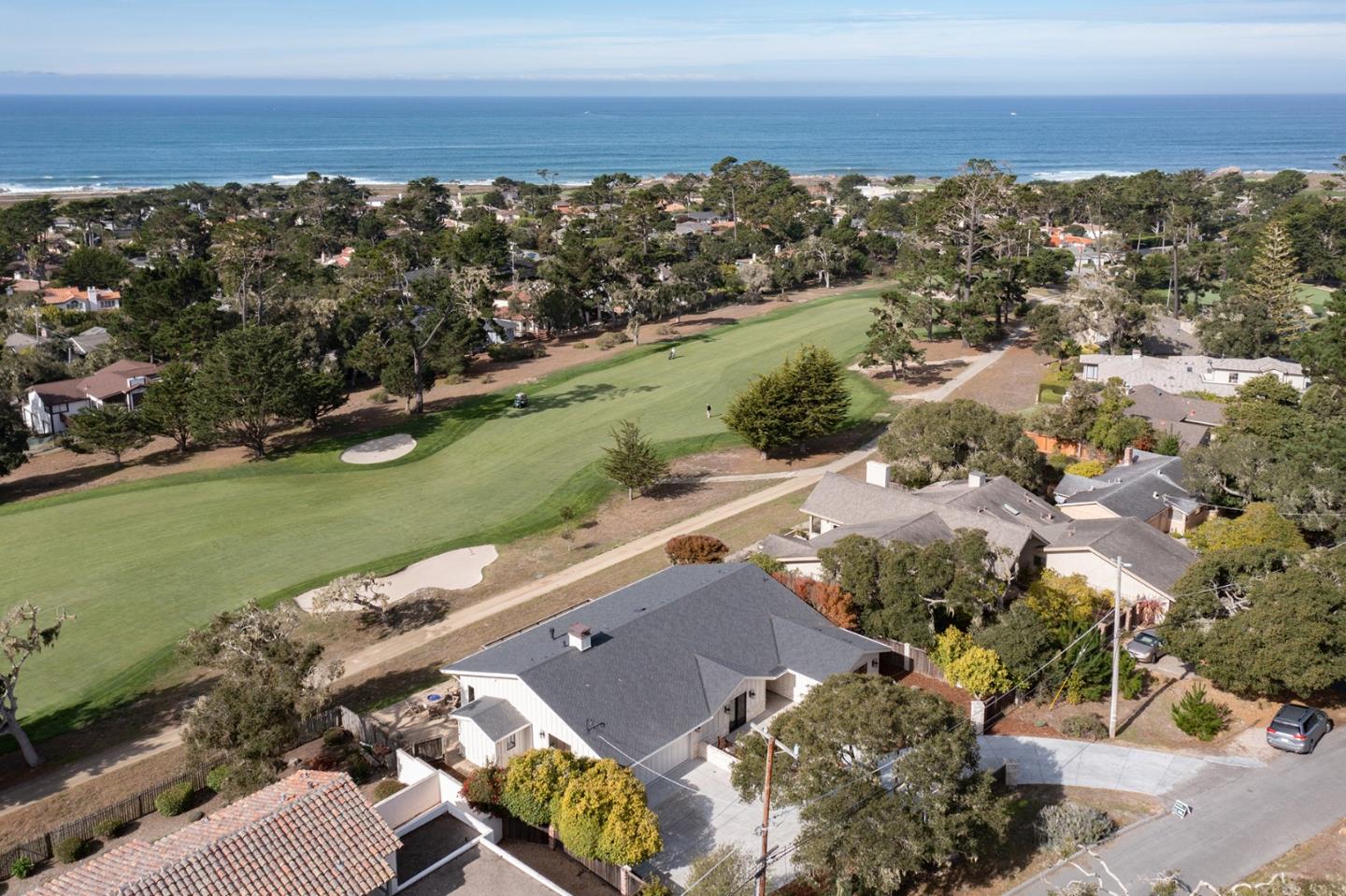 an aerial view of a city with lots of residential buildings ocean and mountain view in back